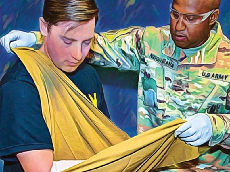 Army medic applies a sling to a soldier.