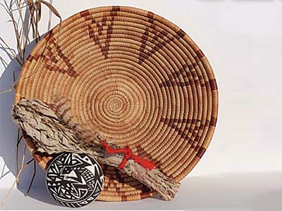 Native American sweetgrass basket leaning against a white wall.
