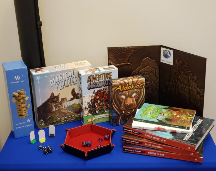 Components of RPG: Tales & Quests on a blue table.