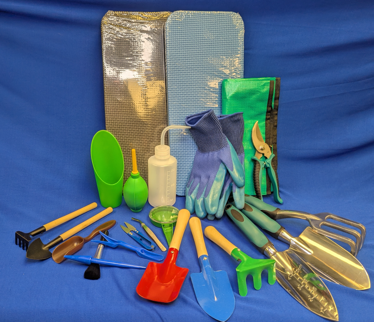 A selection of hand held gardening tools on a blue table.
