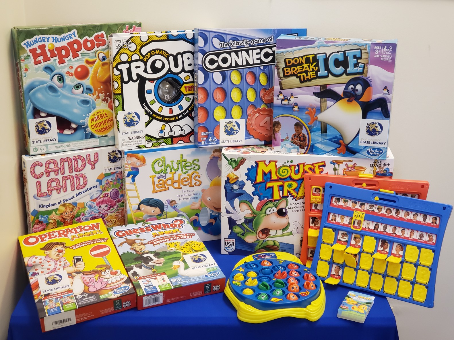 A selection of pre-k board games on a blue table.