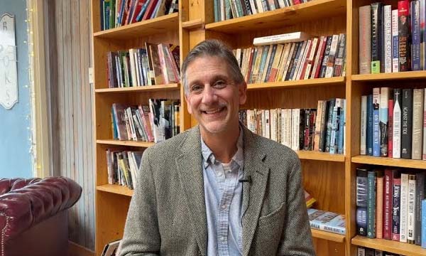Photo of Vincent Sheheen in front of a wall of books.