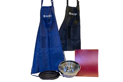 Photo of aprons, bowls and matts on a white background.