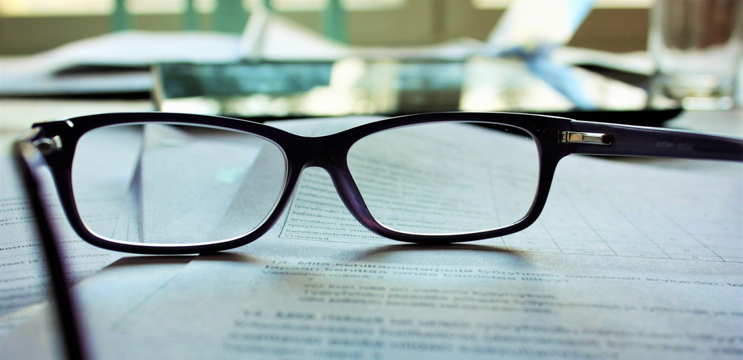 image of a piece of paper and black rimmed glasses