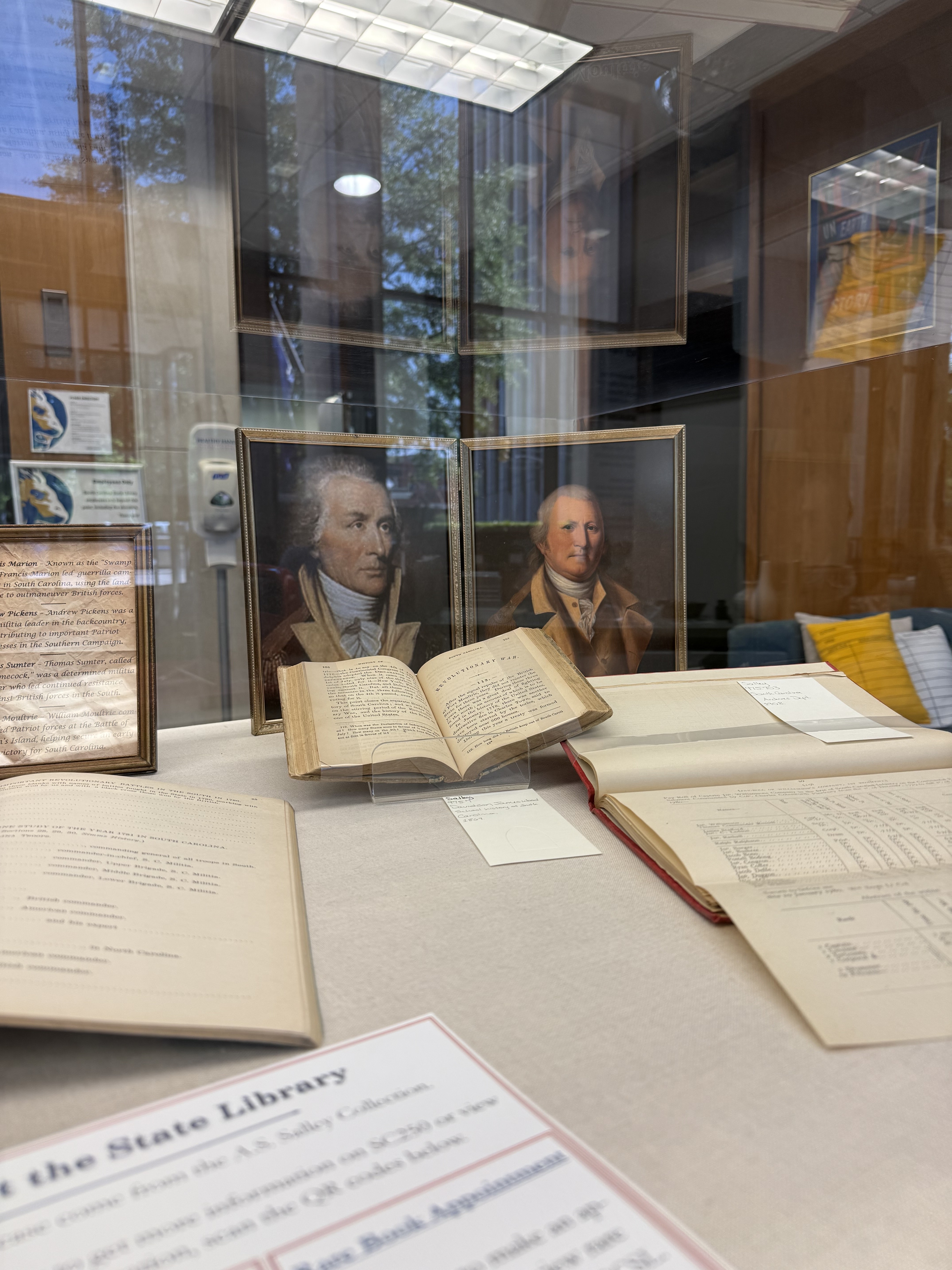 Display case featuring books and paintings.