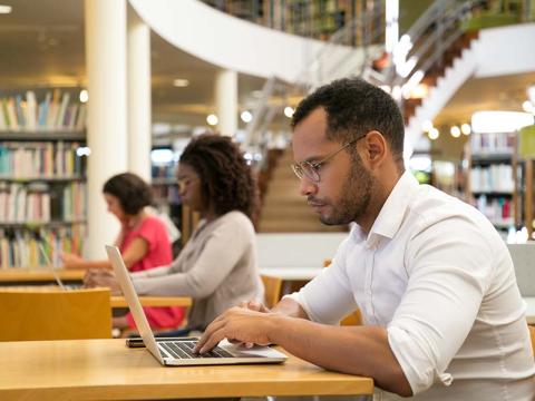 Three library patrons sitting at computers.