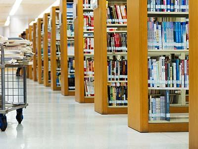 Bookshelves in the library and a library cart.