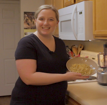 Photo of Lyndsey Maloney holding a bowl of fettuccini alfredo.