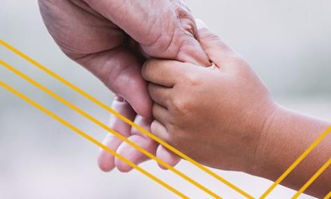 An adult hand holding a child's hand.