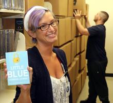 Rebecca Antill, Youth Services Consultant at the South Carolina State Library Foundation, holds up one of the donated books from Amazon