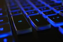 This image shows a computer keyboard with blue back lighting.